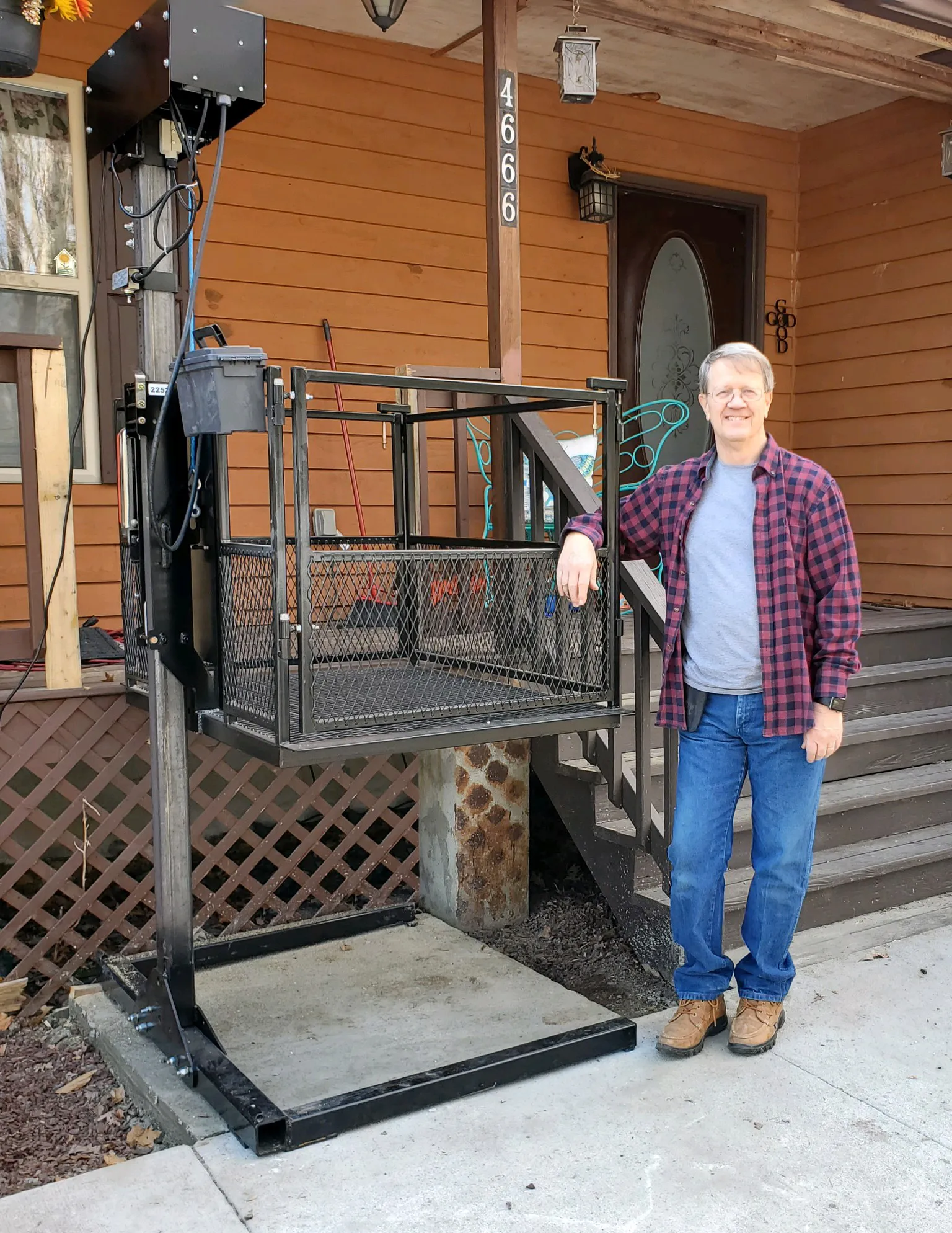 Complete Affordable Lifts vertical platform lift installed beside a porch, shown from platform to column