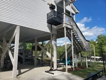 Tall outdoor platform lift serving an elevated deck