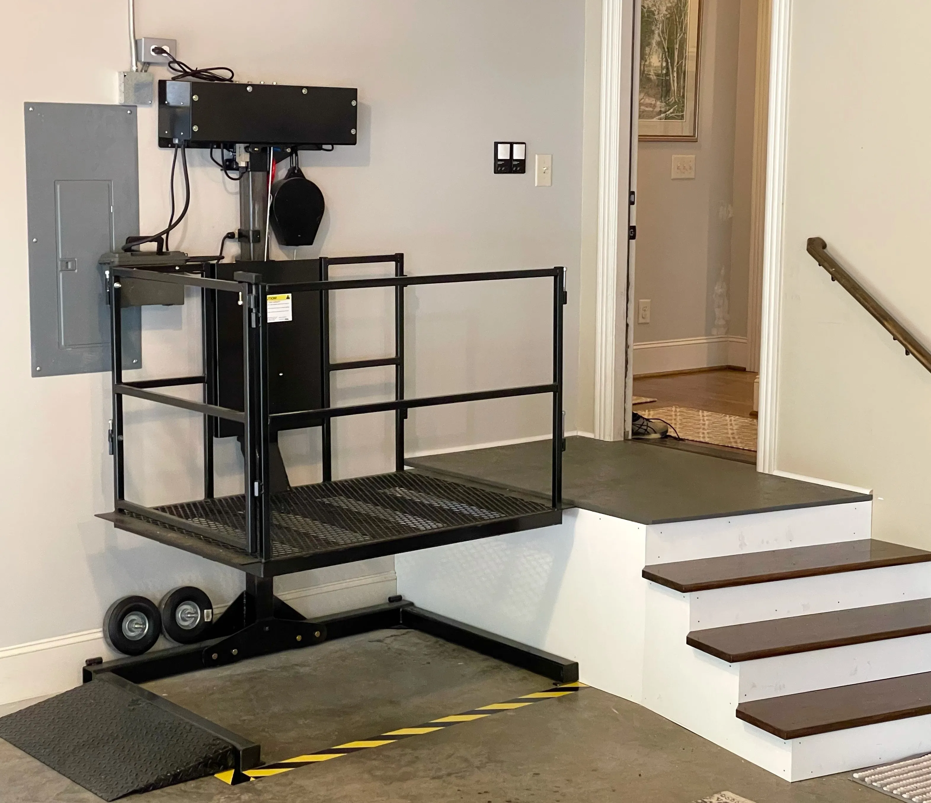 Complete indoor residential platform lift with the platform, column, gates, and landing visible