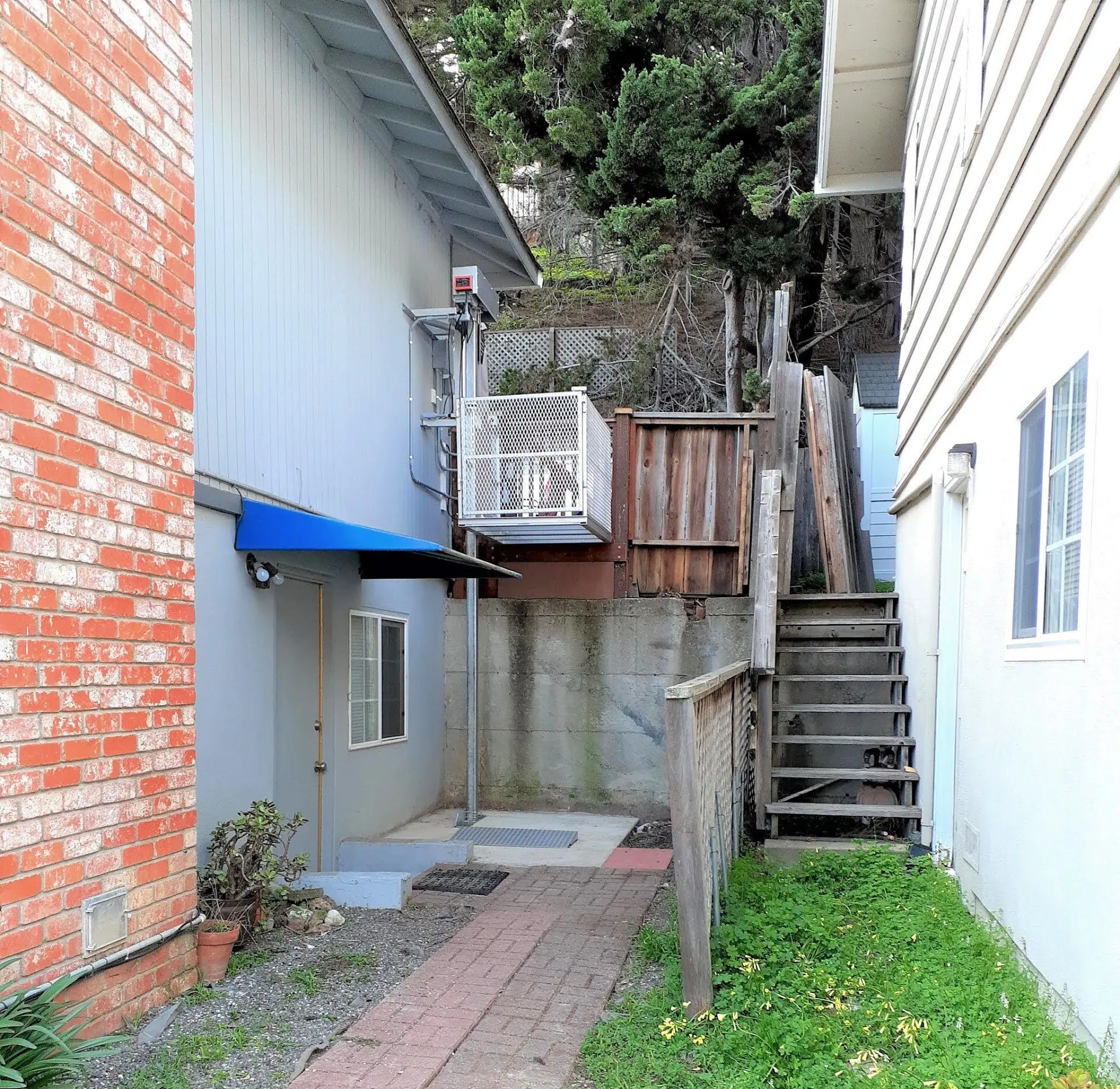 Base-bracket platform lift beside an elevated landing