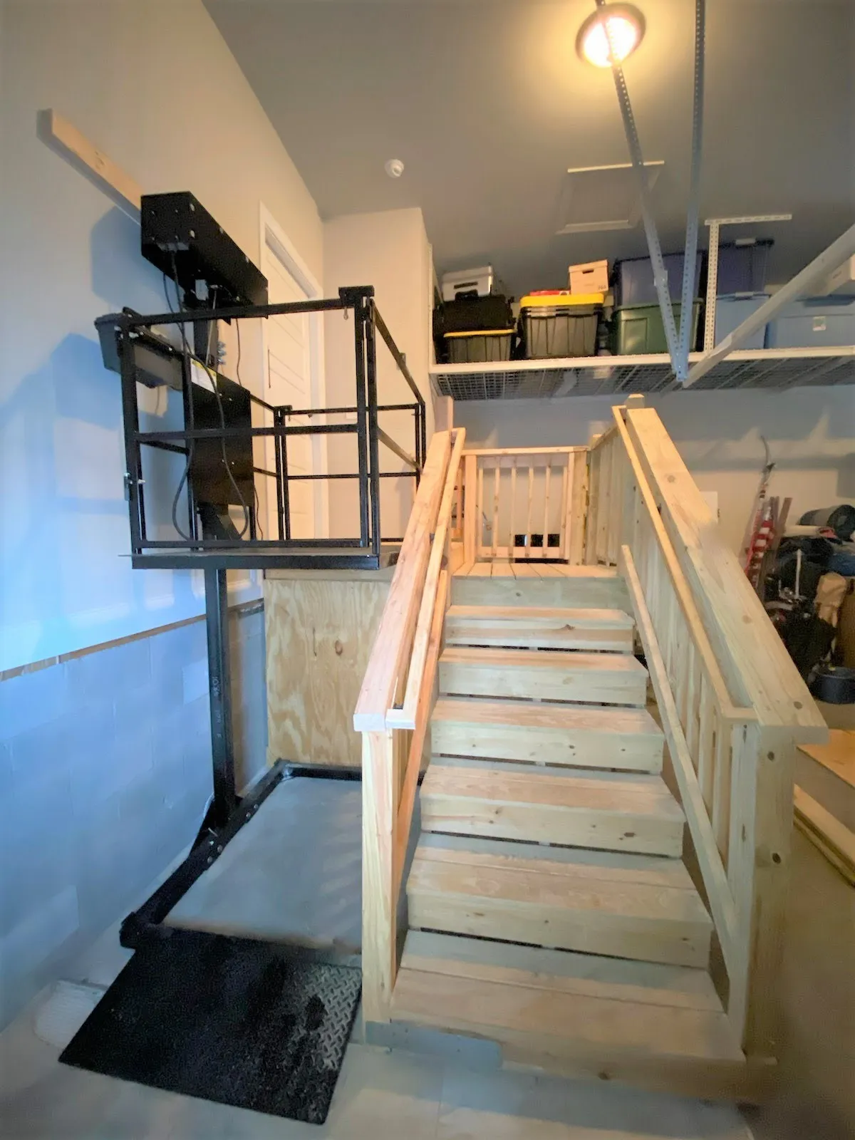 Outdoor lift beside a wood deck and staircase