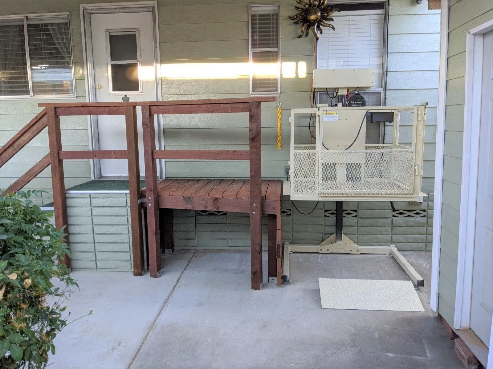 Residential lift serving a raised home entrance